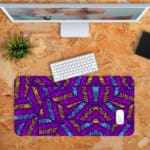 Infidu Vector Pattern Desk Pad with pink and blue leaf-like shapes on a deep purple background, perfect for modern workspaces. Desk Pad with Keyboard and Mouse in orange background