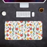 White desk mat with a large floral pattern featuring red, yellow, and blue flowers, and green leaves, adding a vibrant touch to your desk. Desk Pad Design Kept on a computer table