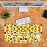 White desk mat with an autumn-themed floral pattern, featuring stylized leaves and flowers in orange, yellow, and green tones. Desk Pad with Keyboard and Mouse in orange background