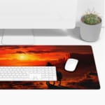 Desert sunset desk pad with a silhouette of a horse rider against a deep orange and red sky, creating a dramatic western scene. Desk Pad with Keyboard and Mouse on top of the desk pad