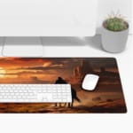 Rider on horseback in a desert with towering rock formations and a warm, colorful sunset sky. Desk Pad with Keyboard and Mouse on top of the desk pad