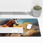 Majestic horse galloping with flowing mane and tail on a colorful abstract background of oranges and blues. Desk Pad with Keyboard and Mouse on top of the desk pad