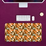 Infidu Geometric Pattern Art Desk Pad with abstract geometric design in orange, black, and white for a modern and dynamic workspace. Desk Pad kept on a pink background