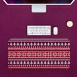 Infidu Desk Pad with a red background, featuring pink, white, and black Christmas trees, reindeer, and snowflakes in a knitted pattern. Desk Pad with Keyboard and Mouse in pink background