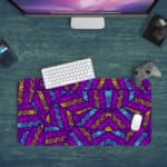 Infidu Vector Pattern Desk Pad with pink and blue leaf-like shapes on a deep purple background, perfect for modern workspaces. Desk Pad with Keyboard and Mouse in green background