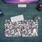 Infidu Vector Pattern Desk Pad with chaotic black and white design, colorful accents, and a white background. Desk Pad kept on a green background