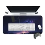 Infidu Space Desk Pad features a deep space view with a star cluster, nebulae, and a bright spot fading into dark blue and purple edges. Desk Mat with a computer