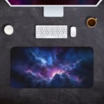 Infidu Space Desk Pad features a nebula with rich purples, blues, and pinks, set against a field of stars and cosmic clouds. Desk Pad kept on a gray background