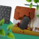 Infidu Explore Nature Desk Mat features a colorful nature scene with deer, autumn-colored trees, and falling leaves in yellow and red tones. Desk Pad with Keyboard and Mouse