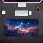 Infidu Space Desk Pad featuring a swirling nebula in orange, pink, and blue set against a starry space background. Desk Pad kept on a gray background