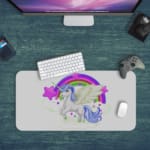 Unicorn Desk Mat with white background, rainbow, and purple stars, and a unicorn with a greenhorn surrounded by clouds. Desk Pad with Design Kept on a computer table