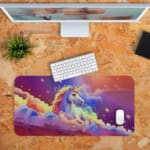 Infidu Unicorn Desk Mat with a colorful background of purple, pink, and blue, featuring a unicorn with a rainbow mane and golden horn. Desk Pad kept on a plain orange background