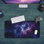 Infidu Space Desk Pad features a nebula scene with rich purples, blues, and a splash of pink, surrounded by stars and cosmic clouds. Desk Pad kept on a green background