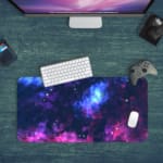 Infidu Space Desk Pad features a vivid, colorful nebula with swirling clouds of gas and dust in blue, pink, purple, and orange hues. Desk Pad with Keyboard and Mouse in green background