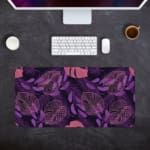 Stylized leaf patterns in lighter shades of purple and pink on the Infidu Bring the Beauty of Flowers Desk Pad with Keyboard and Mouse in gray background