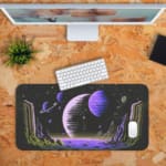 Infidu Space Desk Pad features an abstract alien landscape with geometric rock formations and multiple planets against a black space background. Desk Pad kept on a orange background