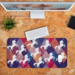 Unicorn Desk Mat with a white unicorn on a colorful background of green, yellow, navy blue, blue, and gray. Desk Pad with Design Kept on a computer table