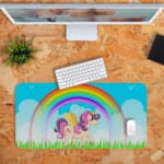 Infidu Unicorn Desk Mat features a colorful forest scene with a unicorn, rainbow, and blue sky, perfect for adding magic to your desk. Desk Pad with Design Kept on a computer table