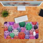 Infidu Discover With Our Owl Theme Children's Desk Mat featuring colorful owls on a pink background. Desk Pad on the computer table in orange background