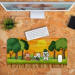 Gaming desk pad with a yellow background featuring a sun, clouds, and playful images of a cat and monkey. Ideal for children’s desks. Desk Pad kept on a plain orange background