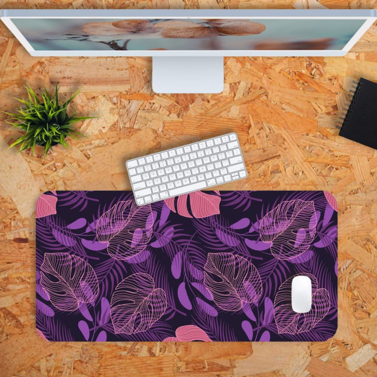 Stylized leaf patterns in lighter shades of purple and pink on the Infidu Bring the Beauty of Flowers Desk Pad with Keyboard and Mouse in orange background