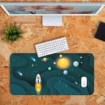 Infidu Space Desk Pad featuring a rocket launch, planets, and stars on a dark teal background. Desk Pad with Keyboard and Mouse