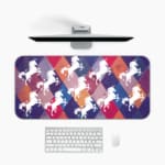 Unicorn Desk Mat with a white unicorn on a colorful background of green, yellow, navy blue, blue, and gray. Desk Pad kept on a plain white background