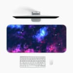 Infidu Space Desk Pad features a vivid, colorful nebula with swirling clouds of gas and dust in blue, pink, purple, and orange hues. Desk Mat with a computer