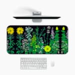 Black desk mat with colorful flower and plant illustrations, including yellow daisies and green plants, featuring a unique design. Desk Mat with a computer