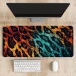 Infidu Vibrant Leopard Print Desk Pad featuring a brown and yellow leopard pattern transitioning to blue and black. desk pad kept on the table