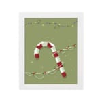 Candy cane with red and white stripes, surrounded by colorful Christmas lights on a light grey or muted green background with a plain white background in a white frame