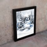 Infidu A Joyous Holiday Wall Art - Tranquil Winter Forest Scene with Deer shows a snowy forest with evergreen trees, a blue house, and a deer. displayed on the wall in black frame