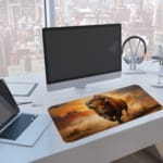 Charging bison desk pad with a realistic bison and prairie background design. A computer and laptop are next to the desk pad