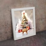 Christmas wall art featuring a white tree with red ornaments, gifts underneath, a reindeer, and a snowy background in a watercolor style. displayed on the wall in a white frame