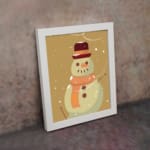 Snowman illustration with a red hat and orange scarf, framed in black, with snowflakes on a light beige background. on the wall in a white frame