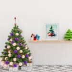 Watercolor Christmas tree painting with green, blue, and red colors, topped with a yellow star, framed in black. displayed on the table in a white frame