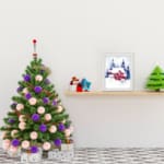 Christmas wall art featuring a pink house and blue pine trees in a watercolor style with a light background. displayed on the table in a white frame