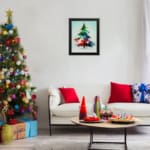 Watercolor Christmas tree painting with green, blue, and red colors, topped with a yellow star, framed in black. displayed on the wall in a black frame