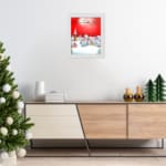 Santa Claus flying in a sleigh with reindeer against a red background, full moon, and snowy village. hung on the wall in a white frame