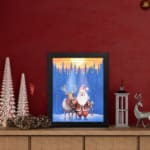 Christmas wall art with a colorful, patterned background featuring festive designs. displayed on the table in a black frame