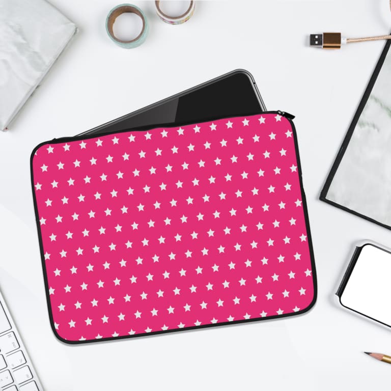 Pink laptop sleeve with a repeating white star pattern, shown against a bright background. laptop sleeve kept on a plain white background