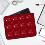 Red laptop sleeve with a playful white heart pattern on a bold red background, designed by digital artists for style and protection. laptop sleeve kept on a plain white background