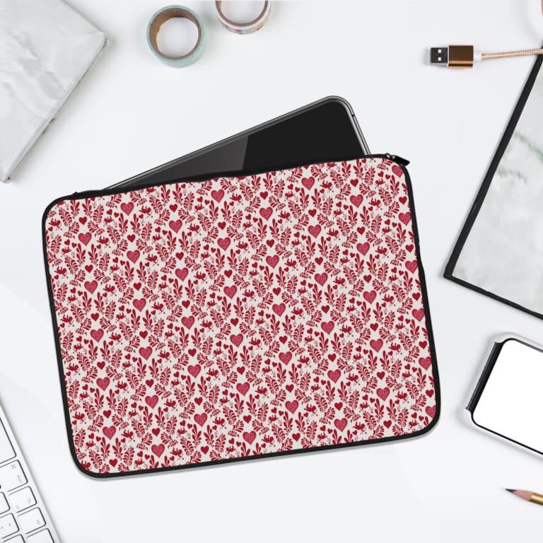 Infidu White Laptop Sleeve with a red heart pattern on a white background, displayed with laptop, rings, and pen on a light surface. laptop sleeve kept on a plain white background