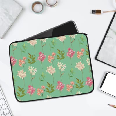 Light green laptop sleeve with pink and white floral design and green leaves. laptop sleeve kept on a plain white background