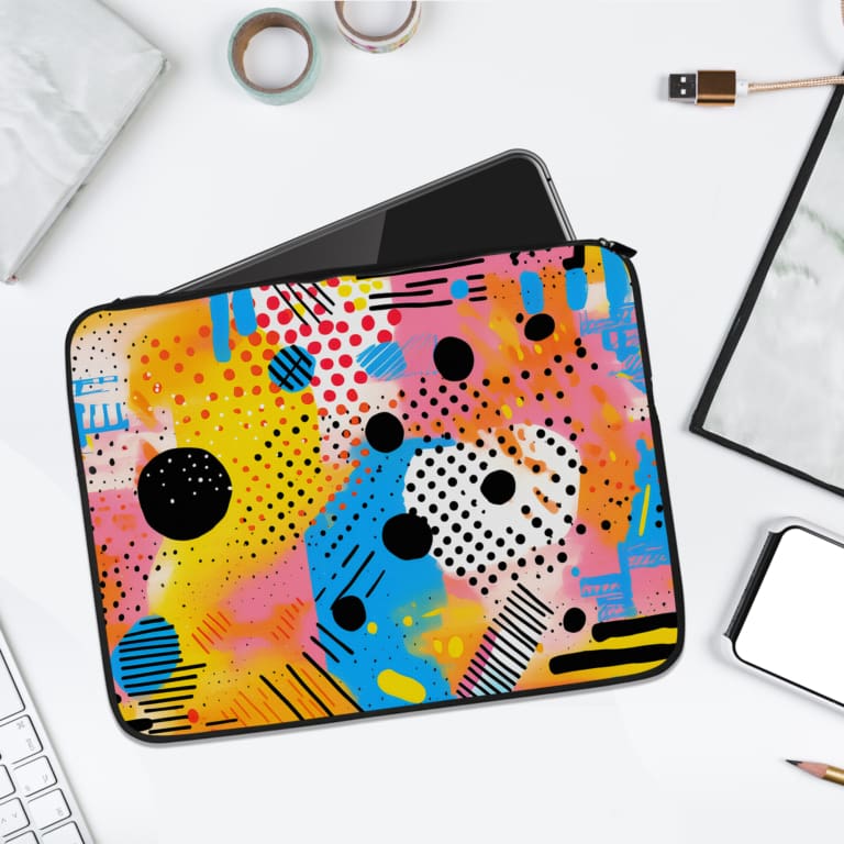 Laptop sleeve with vibrant abstract design in yellow, blue, pink, and black with circles, lines, and dots. laptop sleeve kept on a plain white background