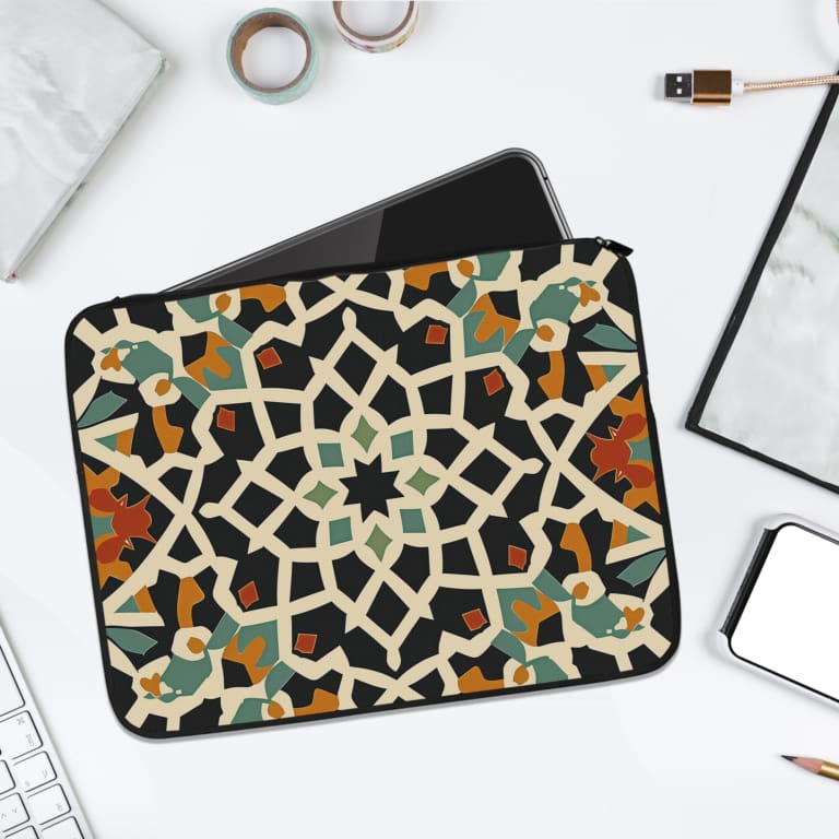 Infidu Traditional Geometric Laptop Sleeve with a bold multicolored pattern in white, black, orange, green, and blue on a dark background. laptop sleeve kept on a plain white background