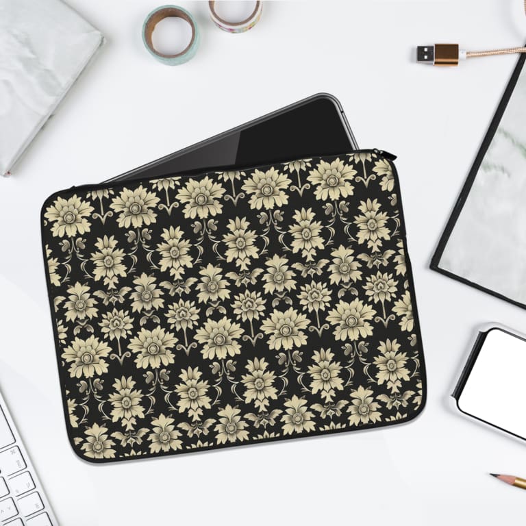 Black laptop sleeve with white floral pattern, detailed and symmetrical, for a bold and classic look. laptop sleeve kept on a plain white background