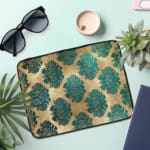 Infidu Vintage Floral Laptop Sleeve in blue, teal, and beige, with a classic floral pattern designed for laptop protection and style. the laptop sleeve on the table