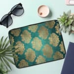 Infidu Elegant Dark Teal Floral Laptop Sleeve with beige and silver floral pattern on a dark teal background. the laptop sleeve on the table