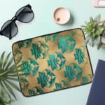 Infidu Beige Floral Design Laptop Sleeve with blue and teal flowers on a beige background. the laptop sleeve on the table